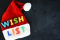 Santa Claus wish list concept with colorful text on SantaÃ¢â¬â¢s red hat Royalty Free Stock Photo